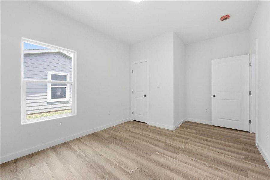 Secondary bedroom featuring great natural light, wood-look flooring, and a spacious closet. Secondary bedroom featuring great natural light, wood-look flooring, and a spacious closet.