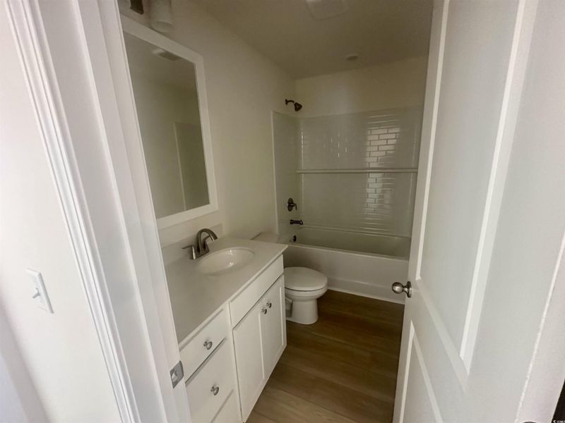 Bathroom with vanity, dark wood finished floors, and shower / tub combination Bathroom with vanity, dark wood finished floors, and shower / tub combination
