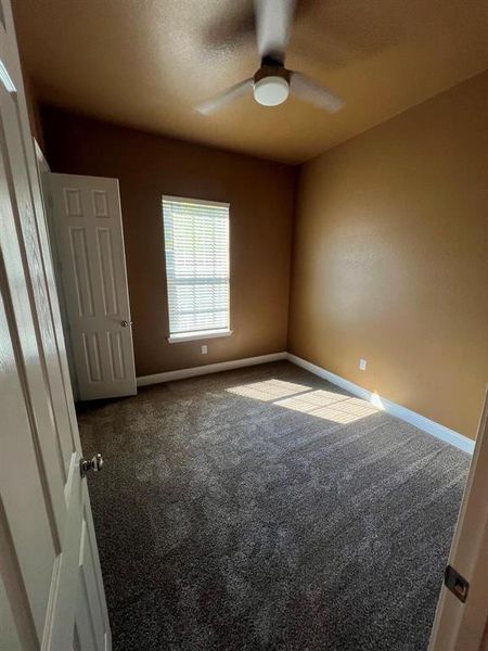 Unfurnished bedroom with carpet and a ceiling fan Unfurnished bedroom with carpet and a ceiling fan