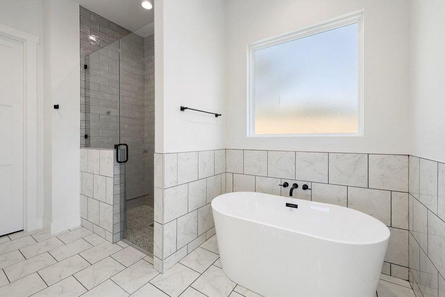 Bathroom with a shower stall, a freestanding bath, tile walls, a wainscoted wall, and recessed lighting