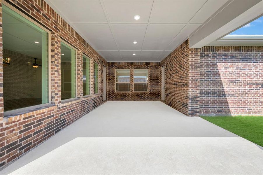 Covered patio featuring a concrete surface, recessed lighting, and brick exterior walls Covered patio featuring a concrete surface, recessed lighting, and brick exterior walls