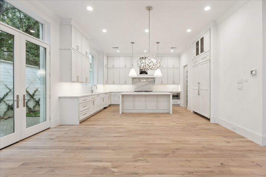 The kitchen showcases a premium Thermador appliance package, which includes a 48” Pro Harmony gas range, a 24” built-in MicroDrawer microwave, a 24” custom panel dishwasher, a 30” custom panel fresh food refrigerator, and 30” freezer columns.