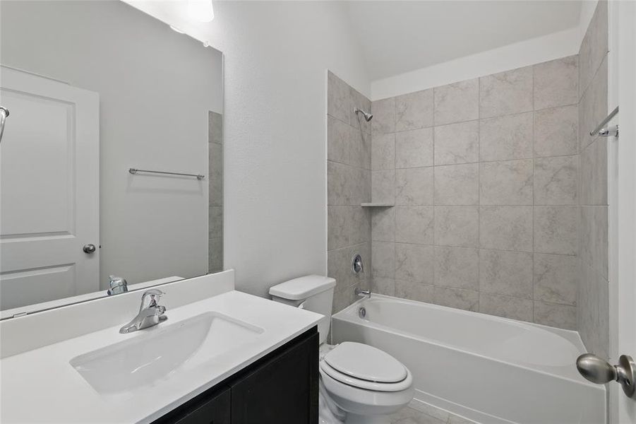 Bathroom with bathing tub / shower combination, vanity, and vaulted ceiling