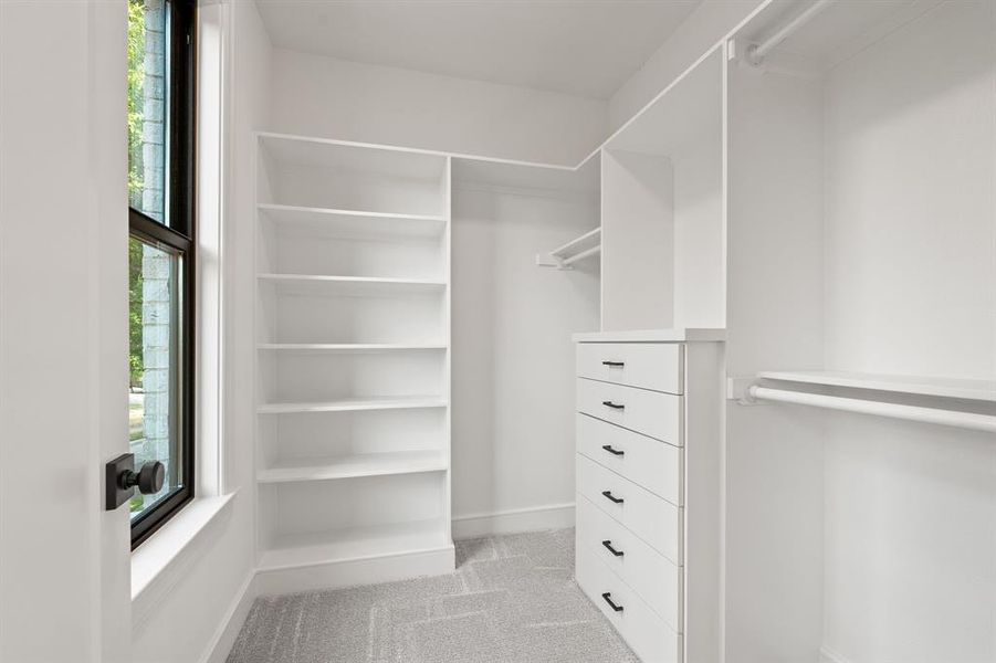 Walk in closet featuring light carpet Walk in closet featuring light carpet