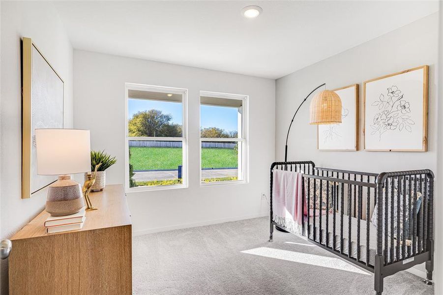 Bedroom with a crib and carpet floors