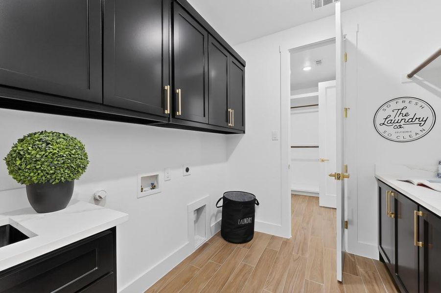 Laundry area with hookup for a washing machine, wood finish floors, cabinet space, hookup for a gas dryer, and electric dryer hookup