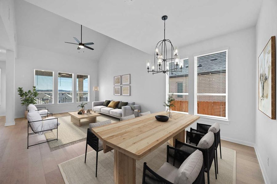 Dining space featuring ceiling fan, light wood-style floors, a chandelier, and high vaulted ceiling Dining space featuring ceiling fan, light wood-style floors, a chandelier, and high vaulted ceiling