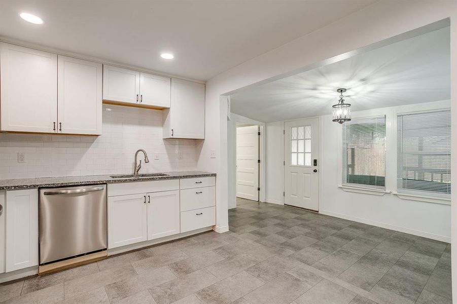 Kitchen and dining with stainless steel dishwasher, decorative backsplash, dark stone countertops, and recessed lighting