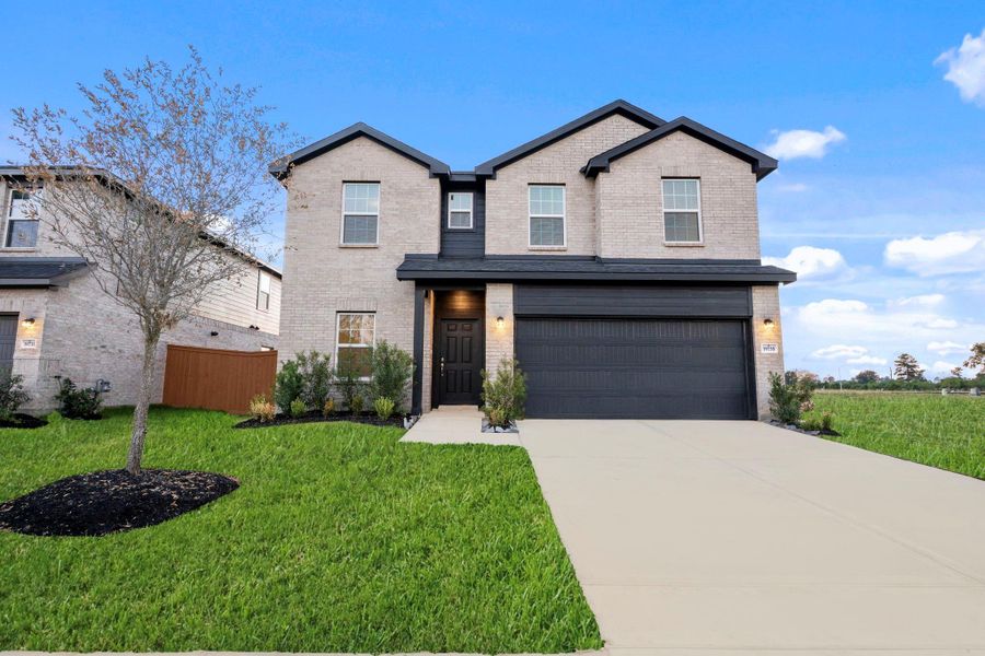 A clear front view displays the home’s welcoming design and manicured lawn, creating a strong first impression for guests and visitors. The modern lines and tasteful brickwork offer timeless appeal.