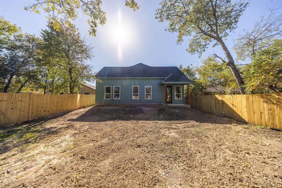 Rear view of property featuring a fenced backyard, a patio area, and roof with shingles