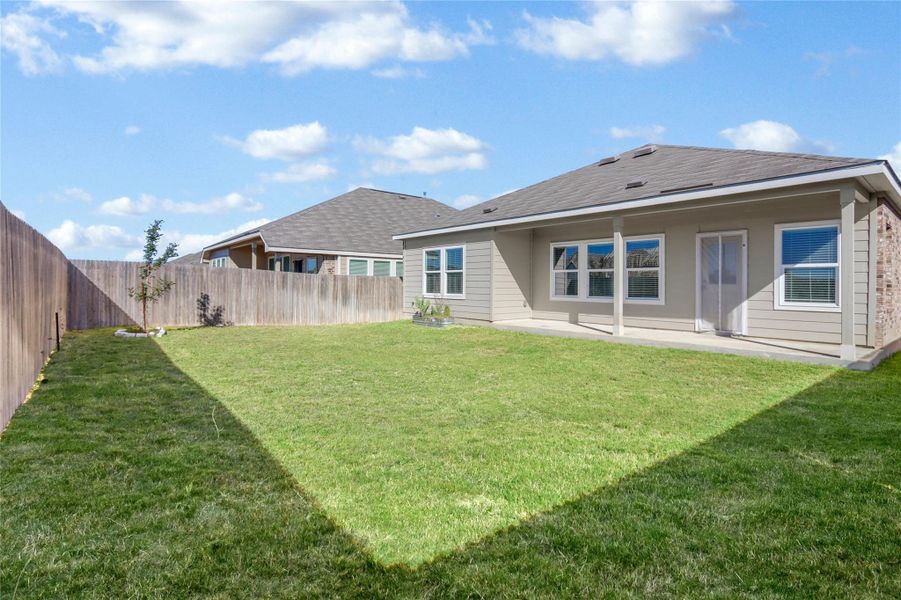 Rear view of house with a patio area, a fenced backyard, and roof with shingles