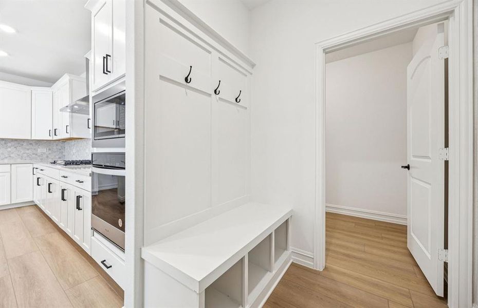 Convenient mud room with built-in bench and hooks for easy organization Convenient mud room with built-in bench and hooks for easy organization