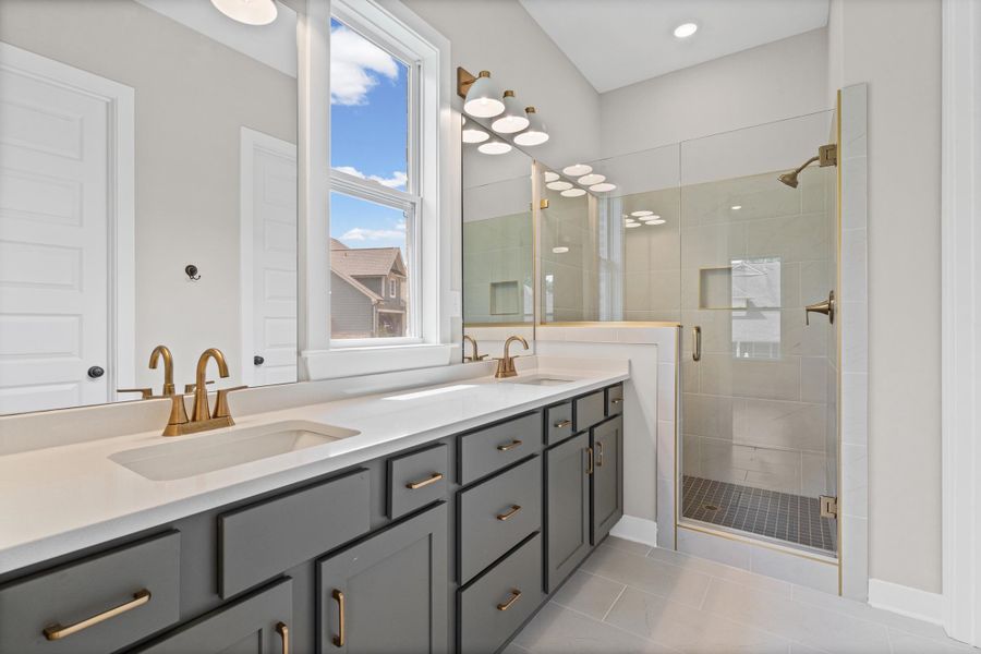 Dual vanity featuring undermount sinks, bronze finish hardware, and a stone countertop Dual vanity featuring undermount sinks, bronze finish hardware, and a stone countertop