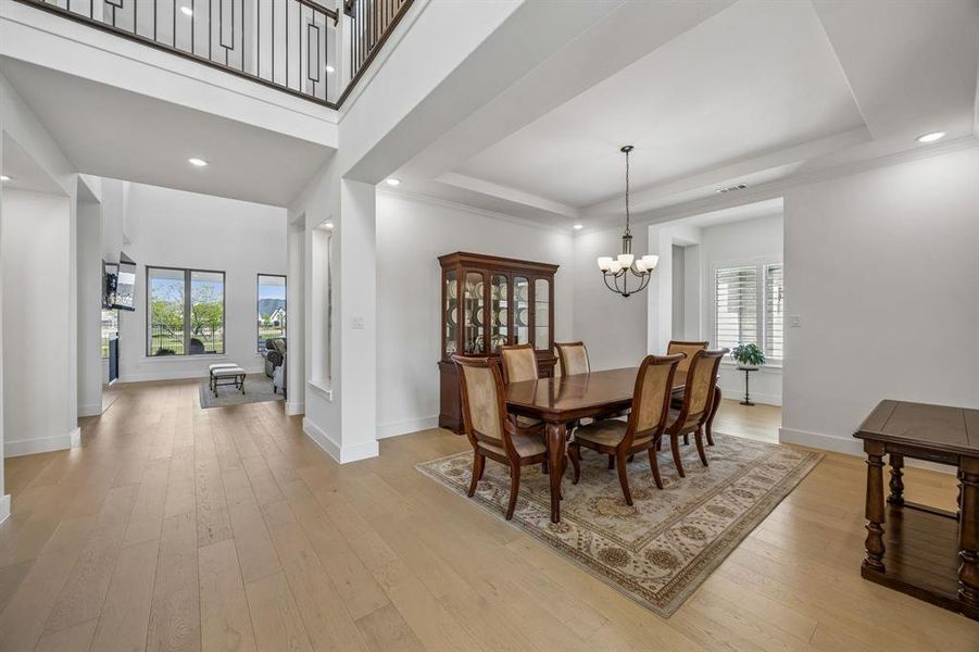 Dining space with light wood-style flooring and suspended lighting