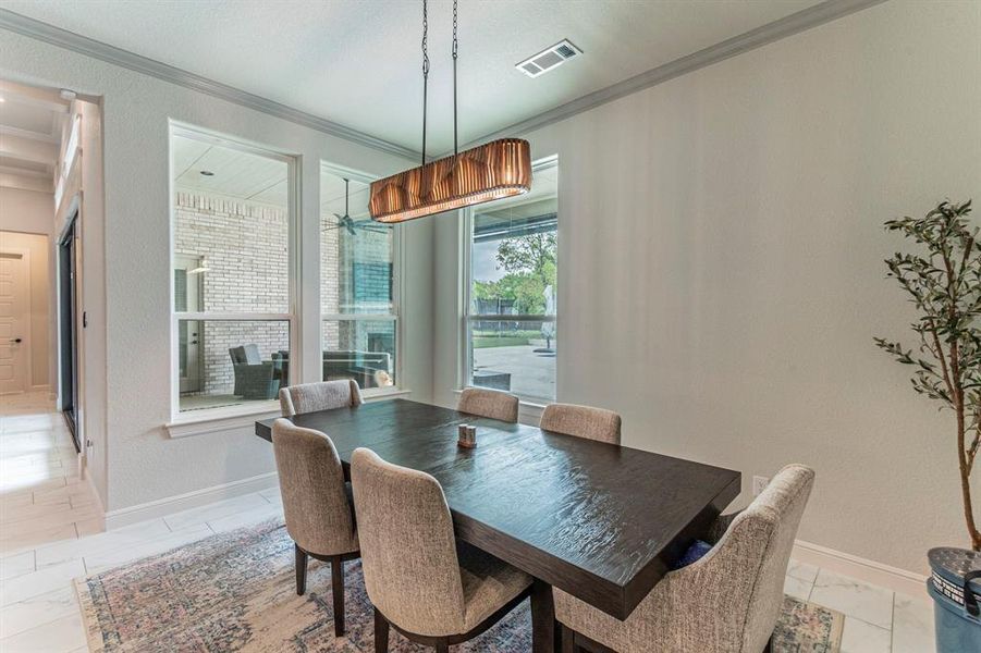 Dining room with crown molding and a textured wall Dining room with crown molding and a textured wall