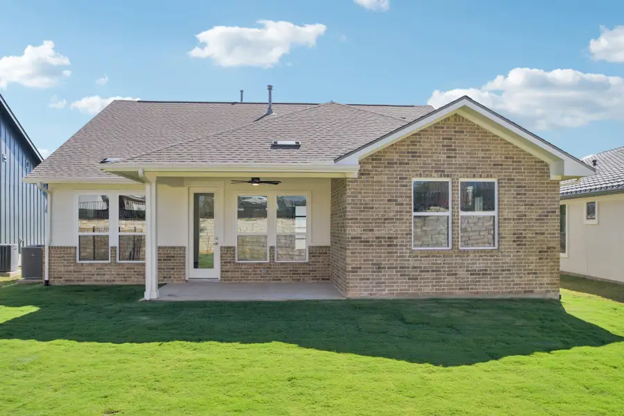 Back of house with a lawn, a patio area, ceiling fan, brick siding, and a shingled roof