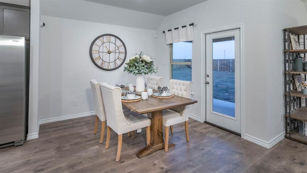 Dining room with dark wood-style flooring and lofted ceiling Dining room with dark wood-style flooring and lofted ceiling