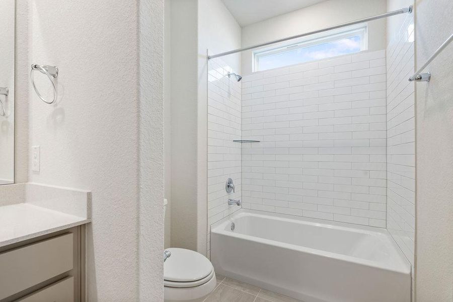 Bathroom with vanity, a textured wall, washtub / shower combination, and light tile patterned floors