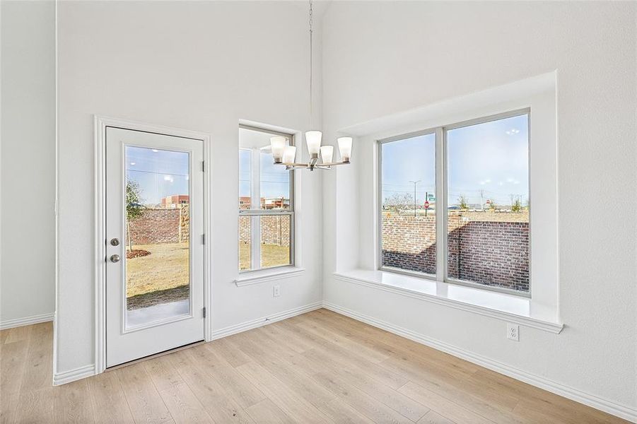 Unfurnished dining area with light wood-style floors and a chandelier Unfurnished dining area with light wood-style floors and a chandelier