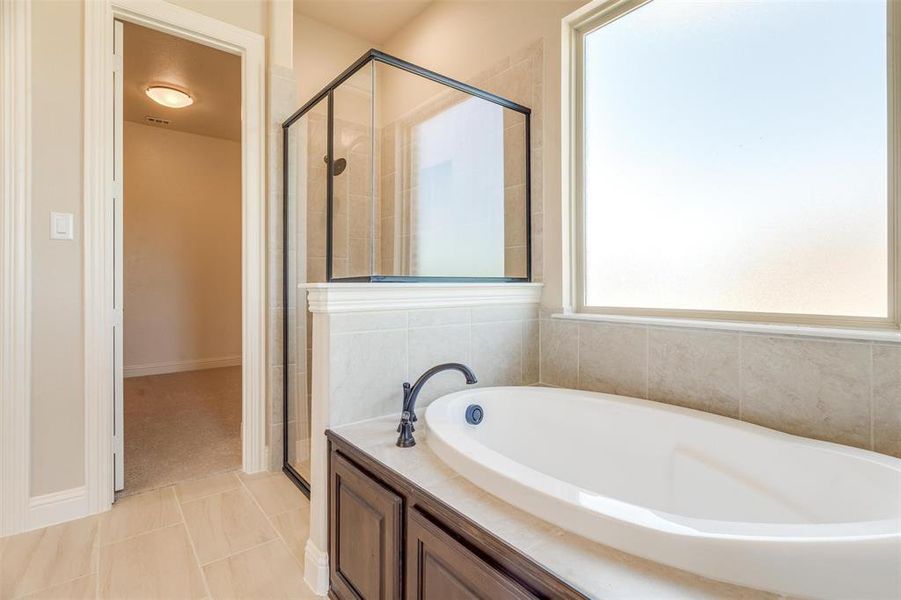 Bathroom featuring tile patterned flooring and independent shower and bath