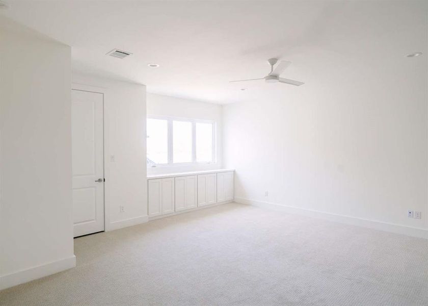 Carpeted empty room featuring ceiling fan