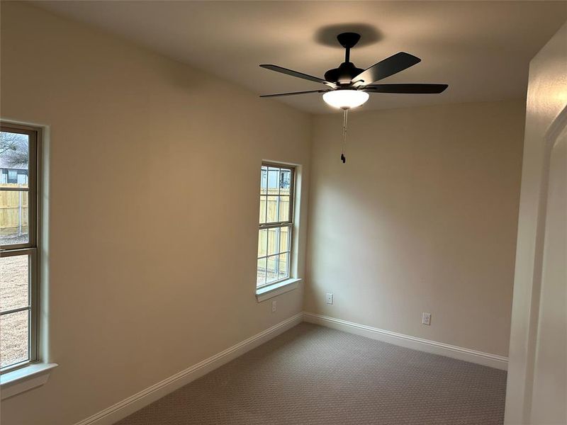 Primary bedroom with carpeting, walk-in closet, ceiling fan and a bathroom with shower and dual vanities.