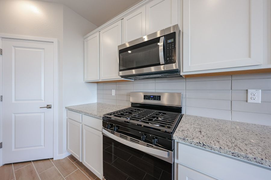 A kitchen with white cabinets.