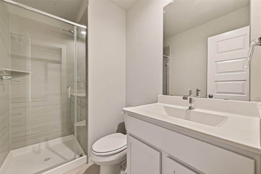 This en-suite bathroom features a shower and a single sink, providing a functional and private space.