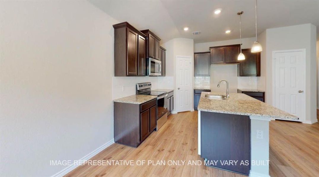 Kitchen featuring stainless steel appliances, dark brown cabinets, decorative backsplash, light wood-style flooring, and recessed lighting Kitchen featuring stainless steel appliances, dark brown cabinets, decorative backsplash, light wood-style flooring, and recessed lighting