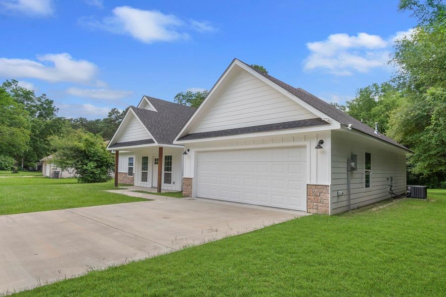 Charming single-story home with a modern design, featuring a spacious two-car garage, clean siding, and stone accents. It sits on a well-maintained grassy lot with mature trees, offering a peaceful and inviting atmosphere. Charming single-story home with a modern design, featuring a spacious two-car garage, clean siding, and stone accents. It sits on a well-maintained grassy lot with mature trees, offering a peaceful and inviting atmosphere.