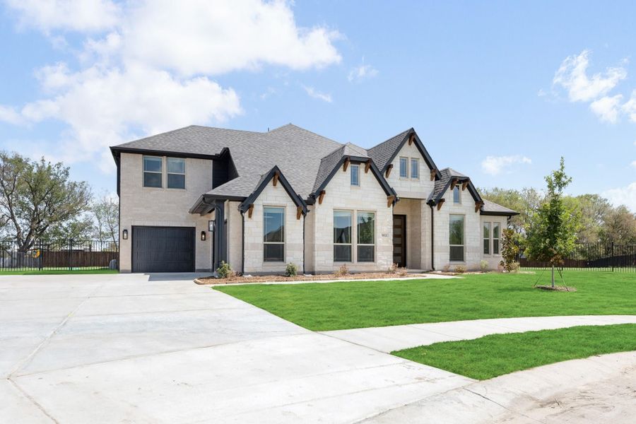 Two-story home with light stone exterior, dark roof, single-car garage, and green front lawn