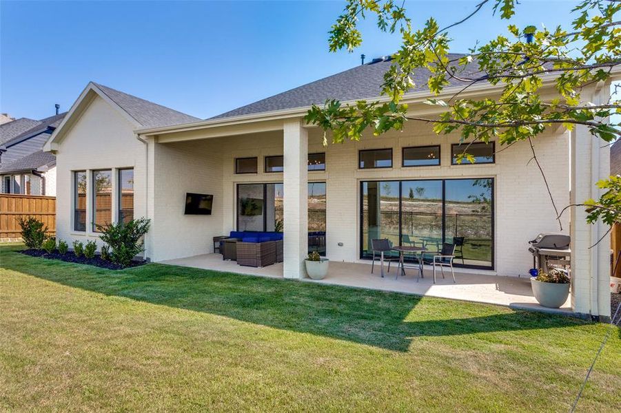 Rear view of house featuring a patio area, brick siding, an outdoor living space, and a shingled roof Rear view of house featuring a patio area, brick siding, an outdoor living space, and a shingled roof