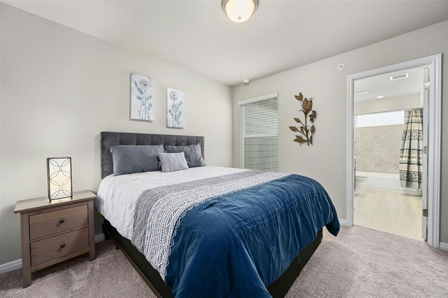 Bedroom with ensuite bath and carpet