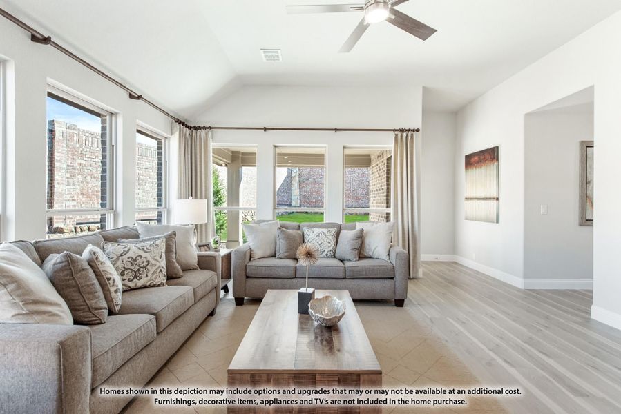 Living room with vaulted ceiling, ceiling fan, two gray sofas, wood coffee table, and large windows with natural light. Living room with vaulted ceiling, ceiling fan, two gray sofas, wood coffee table, and large windows with natural light.