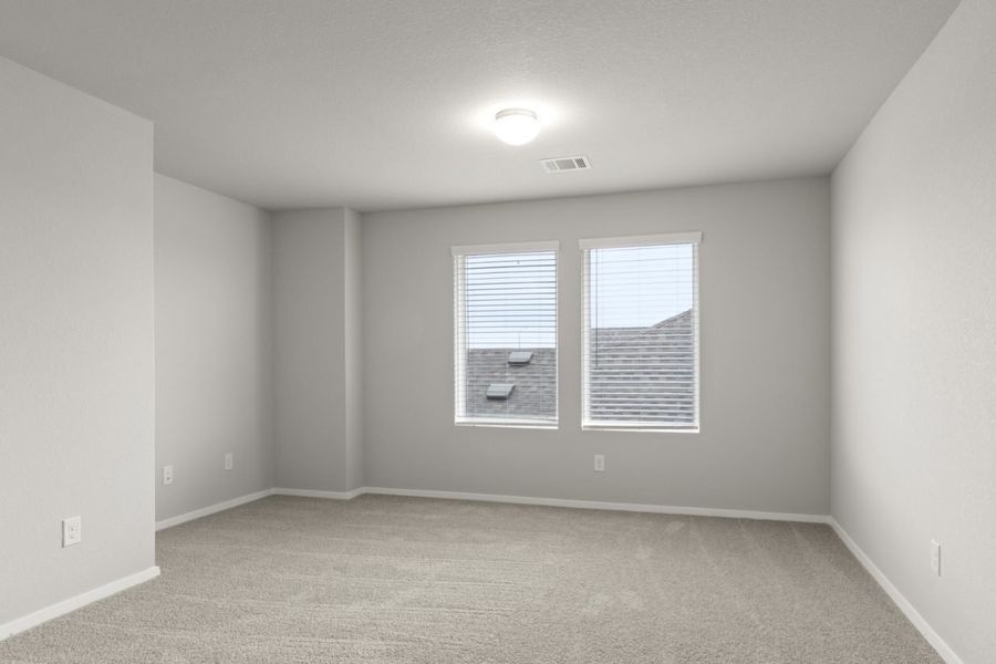 Image of a flex space area with tan carpeting and light grey walls with two large windows