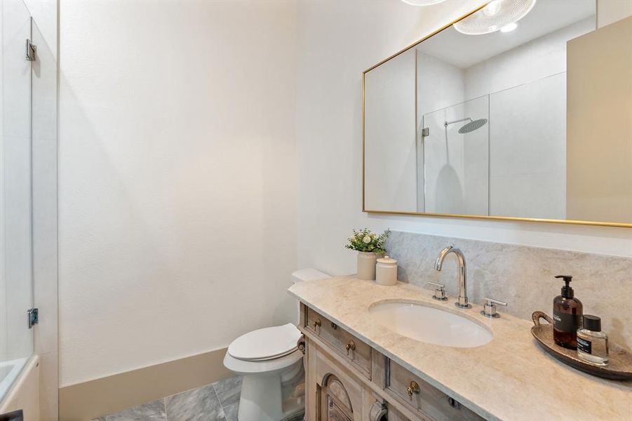 Bathroom featuring tile floors, toilet, and vanity with extensive cabinet space