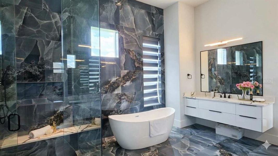 Spacious bathroom featuring a freestanding soaking tub, a large walk-in shower with glass enclosure, a dual-sink floating vanity with white countertops, and expansive floor-to-ceiling dark veined tile
