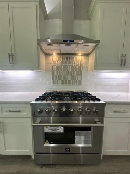 Custom tile backsplash highlights a 36in, 6 burner duel fuel Forno stove