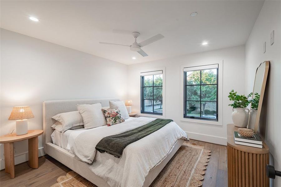 Bedroom with connected bathroom, light hardwood / wood-style floors, and ceiling fan