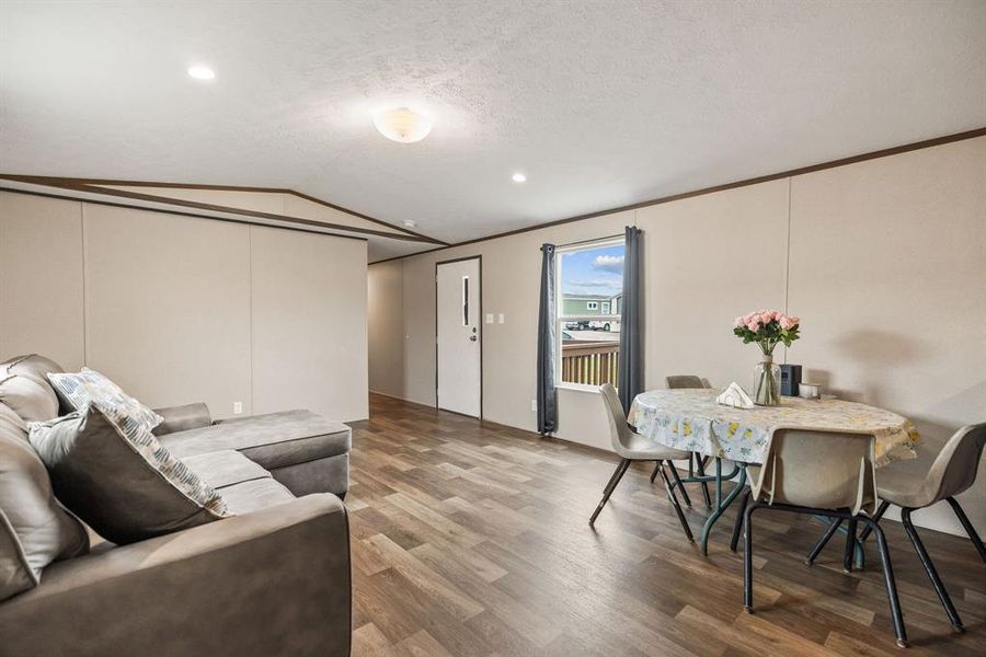 Open-concept interior featuring wood-finish flooring, recessed lighting, and a neutral color palette Open-concept interior featuring wood-finish flooring, recessed lighting, and a neutral color palette