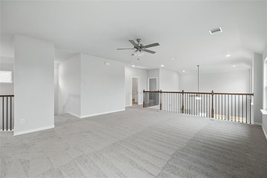 Carpeted empty room featuring ceiling fan and recessed lighting