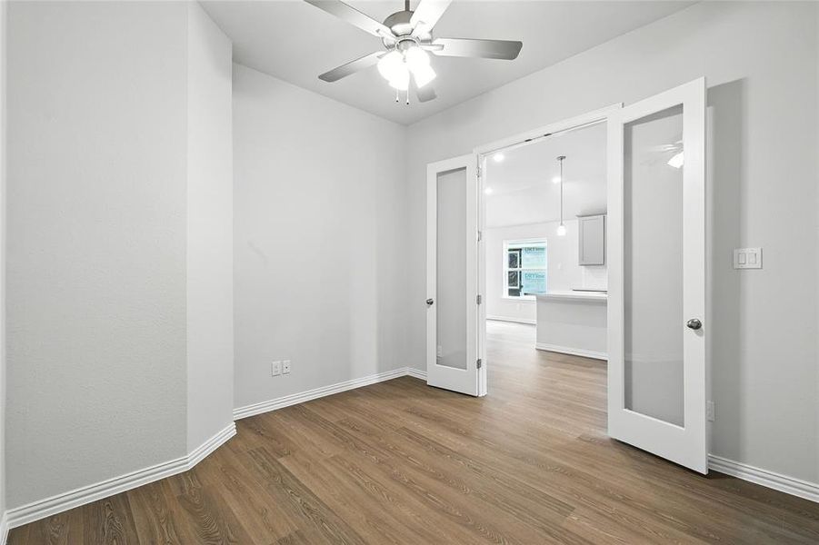 Spare room with dark wood-type flooring, french doors, and a ceiling fan Spare room with dark wood-type flooring, french doors, and a ceiling fan