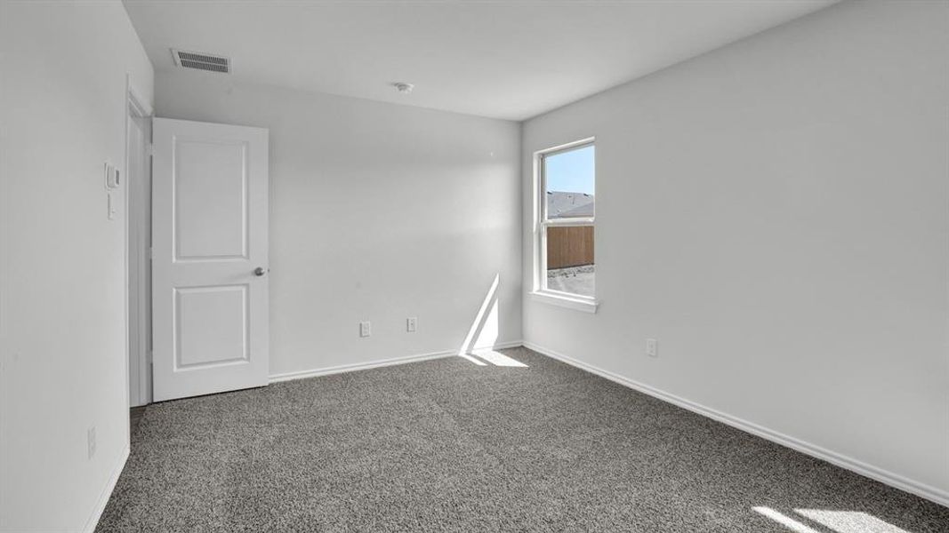 Spare room with dark carpet and baseboards