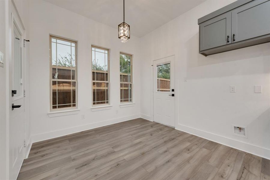 Unfurnished dining area featuring light hardwood / wood-style flooring and an inviting chandelier