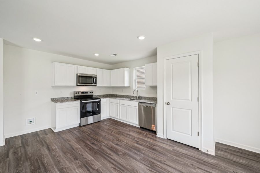 A kitchen with white cabinets.