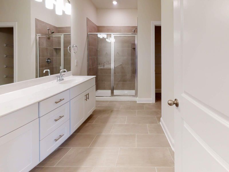 The primary suite's luxurious bathroom offers dual vanity sinks and a large walk-in shower. The primary suite's luxurious bathroom offers dual vanity sinks and a large walk-in shower.