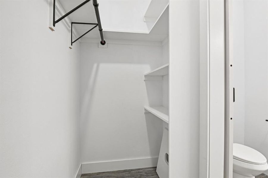 Bathroom with a marble finish shower, vanity, wood finished floors, and a spacious closet Bathroom with a marble finish shower, vanity, wood finished floors, and a spacious closet