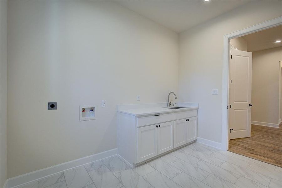 Laundry has sink and counter, room for XL washer/dryer.