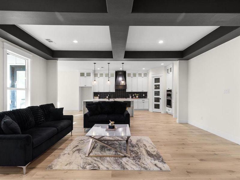 Living room with light wood finished floors, recessed lighting, and coffered ceiling