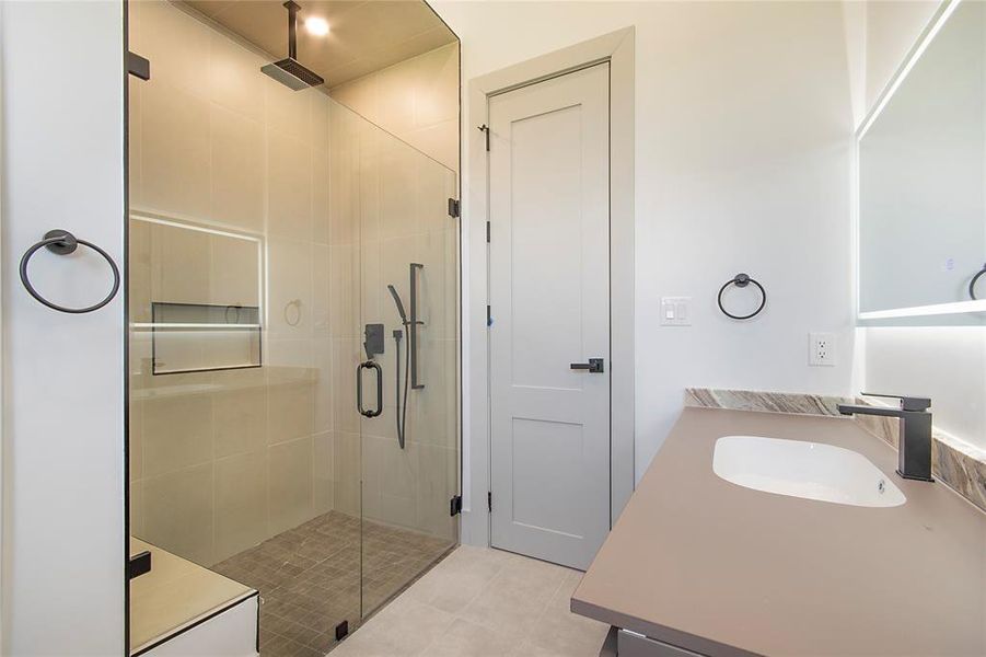 Bathroom with vanity, a shower stall, and tile patterned flooring